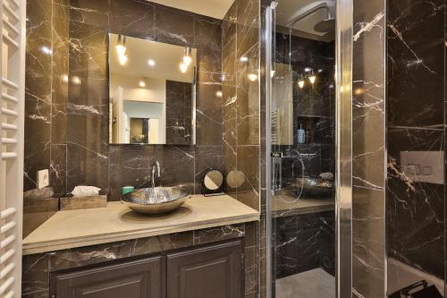 une salle de bain avec un lavabo et une douche avec un miroir dans l'établissement Appartement avec toit terrasse équipé au centre Saint Tropez vue mer, à Saint-Tropez