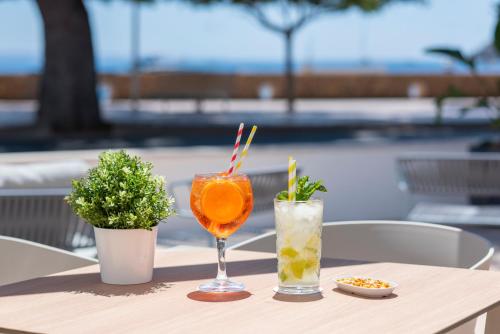 a table with two drinks on a table at Hotel Palia Tropico Playa in Palmanova