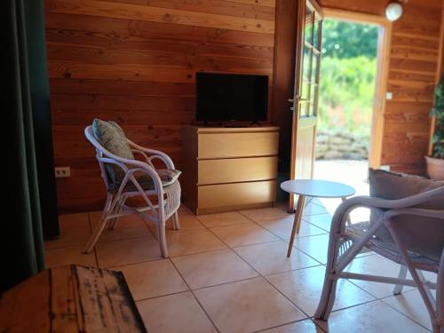 - un salon avec des chaises, une télévision et une table dans l'établissement Gîte jusqu'à 4 personnes, à Prayssas