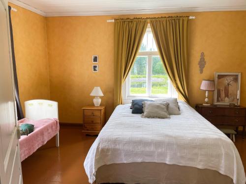 a bedroom with a large bed and a window at Pihlajaharju Countryside Escape in Somero