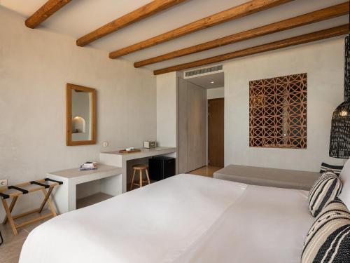 a bedroom with a large white bed and a desk at The Theodore Boutique Hotel- adults only 16 plus in Agia Marina Nea Kydonias