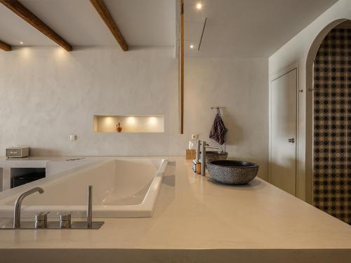 a bathroom with a large tub and a sink at The Theodore Boutique Hotel- adults only 16 plus in Agia Marina Nea Kydonias