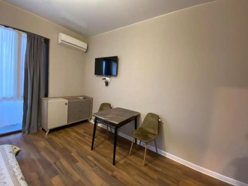 a room with a desk and two chairs and a tv at Lusi sweet home in Batumi