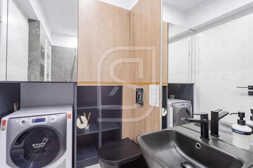 a bathroom with a sink and a washing machine at Aqua by Kristal Collection in Bucharest