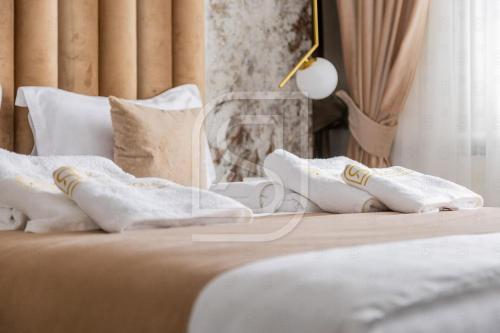 a bed with white towels and pillows on it at Aqua by Kristal Collection in Bucharest