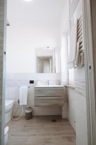 a white bathroom with a sink and a toilet at Gioema in Borgo Vodice