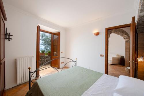 a white bedroom with a bed and a doorway at Casa Allegra in Praiano