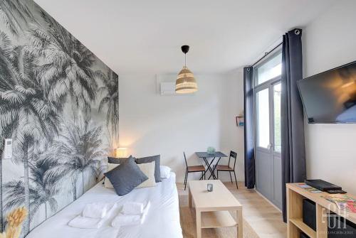 un salon avec un canapé blanc et une télévision dans l'établissement La Jonquille - A 2 min de Tours, à Tours