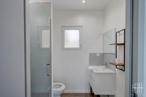 une salle de bain blanche avec des toilettes et un lavabo dans l'établissement La Jonquille - A 2 min de Tours, à Tours