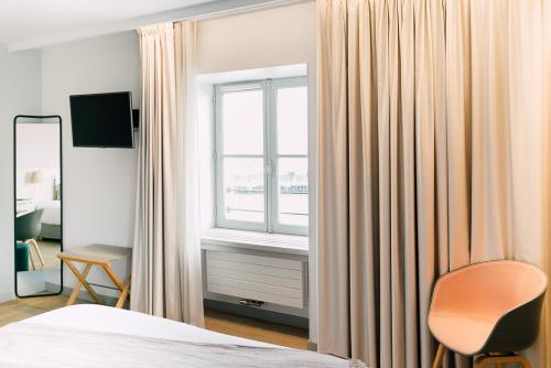 a bedroom with a bed and a window and a chair at Atlantide 1874 - Maison Gueho in Nantes