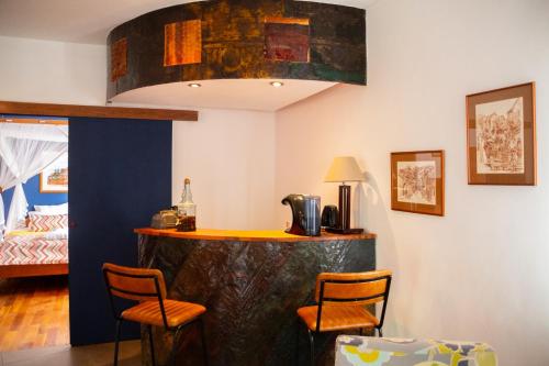a bar in a room with two chairs and a bed at La Varangue in Antananarivo