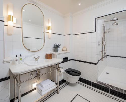 a white bathroom with a sink and a toilet at The White Horses by Everly Hotels Collection in Rottingdean