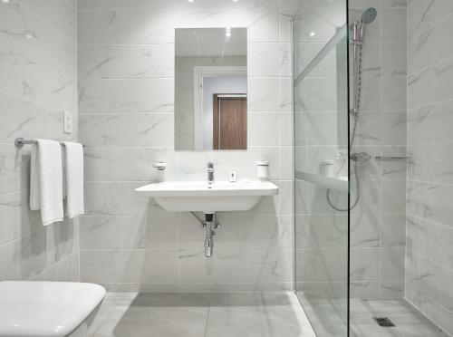 a white bathroom with a sink and a shower at Gaia Sun N Blue Hotel in Ayia Napa