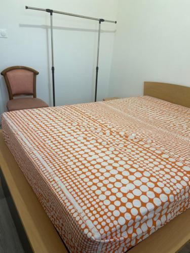 un lit orange et blanc avec une chaise dans une chambre dans l'établissement Le coins sympa, à Lyon