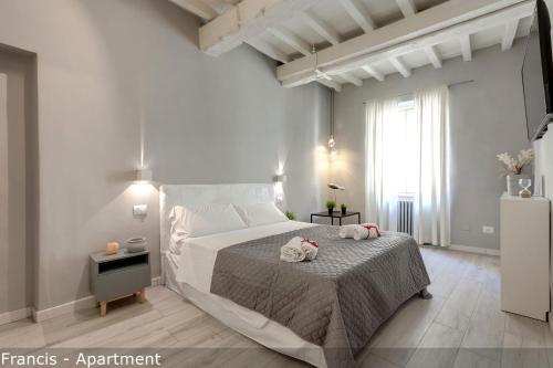 une chambre avec un grand lit avec deux serviettes dessus dans l'établissement Jake & Francis Apartments by Mamo Florence, à Florence