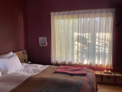a bedroom with a bed and a window with a towel on it at Secret break Hebara in Katsuura