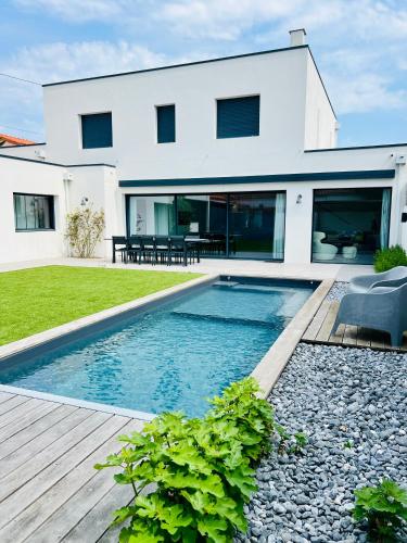 une maison avec une piscine devant une maison dans l'établissement L'Escapade - Villa avec piscine, à La Rochelle