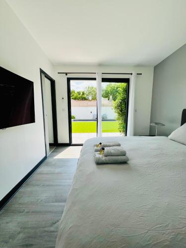 une chambre avec un grand lit avec des serviettes dessus dans l'établissement L'Escapade - Villa avec piscine, à La Rochelle