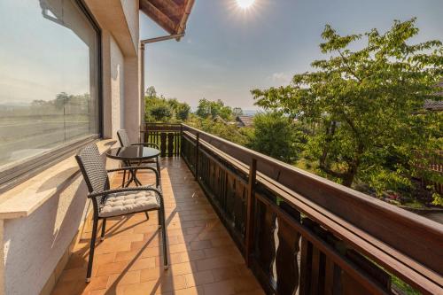 a balcony with two chairs and a table and a view at Hiša Oder in Woditz