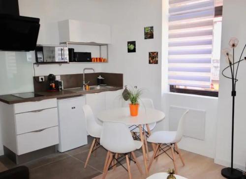 - une cuisine avec une table blanche et des chaises blanches dans l'établissement Tout Beau Tout Neuf, à Toulouse