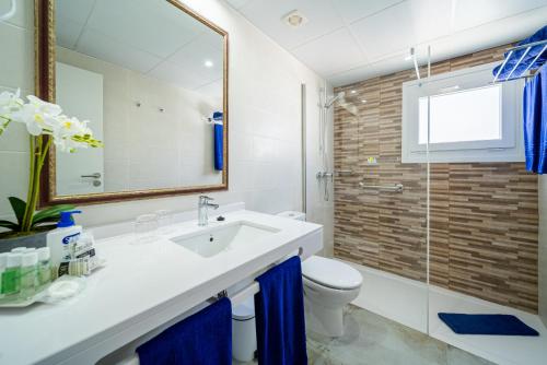 a bathroom with a sink and a toilet and a mirror at Suite Hotel Montana Club in Puerto del Carmen