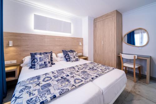 a bedroom with a bed and a desk and a chair at Suite Hotel Montana Club in Puerto del Carmen