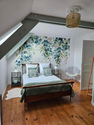 - une chambre avec un lit orné d'un mur fleuri dans l'établissement Les 13 lavoirs d'antan - chambre douceur de vivre, à Saint-Pierre-Église