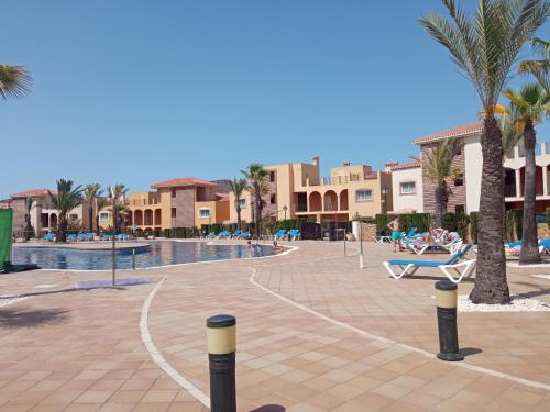 a resort with a pool and palm trees and buildings at ELIO La Manga Club 5, golf & spa in La Manga del Mar Menor