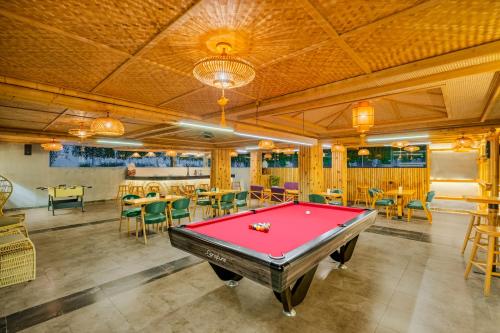 a pool table in a room with tables and chairs at The Saga Hotel Hoi An in Hoi An