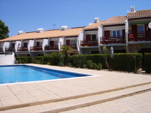 a swimming pool in front of a building at Green Village in La Grande-Motte