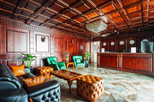 a living room with a table and green chairs at River Inn Hotel in Yakkasaray