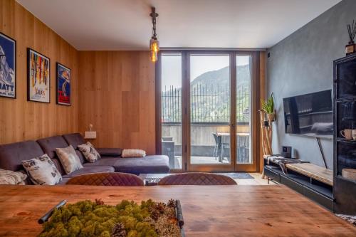 a living room with a couch and a large window at ISARD & SPA by SELECT RENTALS in El Tarter