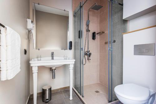 a bathroom with a shower and a sink and a toilet at River Inn Hotel in Yakkasaray