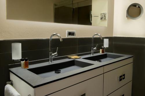 a bathroom with a sink with two faucets at Riva Del Sole Resort & SPA in Castiglione della Pescaia