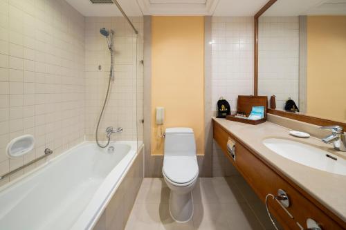 a bathroom with a tub and a toilet and a sink at Lebanshan Hotel Jiuzhai Valley in Jiuzhaigou