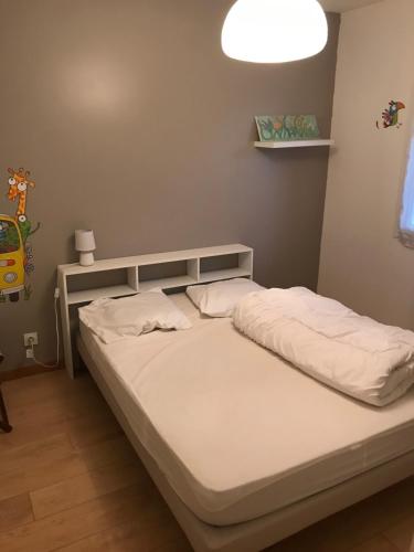 - un lit dans une chambre avec une lumière au-dessus dans l'établissement Villa Piscine, à Gujan-Mestras