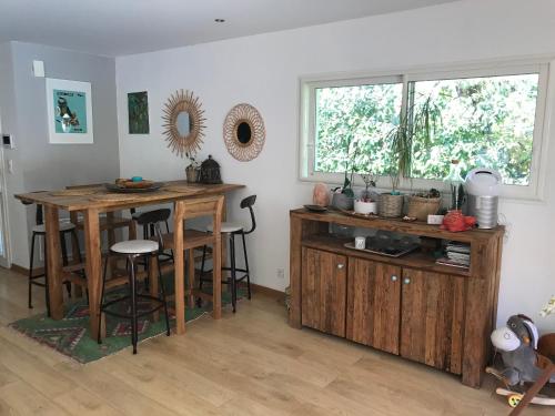 une cuisine avec une table en bois et une fenêtre dans l'établissement Villa Piscine, à Gujan-Mestras