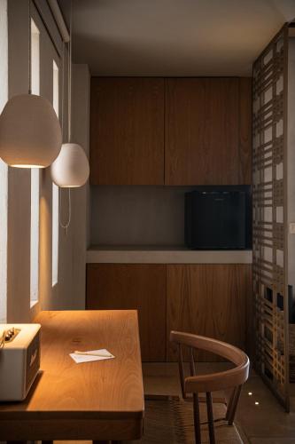 a kitchen with a wooden table and a chair at The Theodore Boutique Hotel- adults only 16 plus in Agia Marina Nea Kydonias