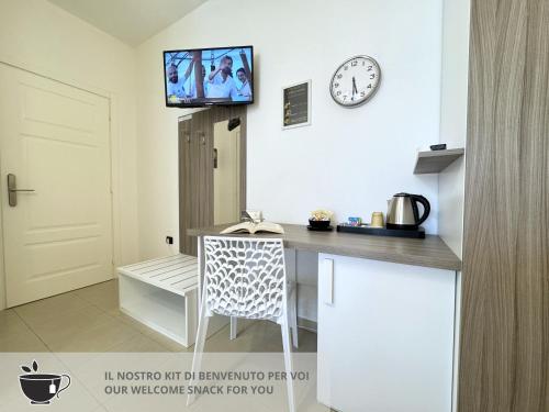 a kitchen with a table and a tv on the wall at B&B CORSO ROMA Room Suite & Spa in Apricena