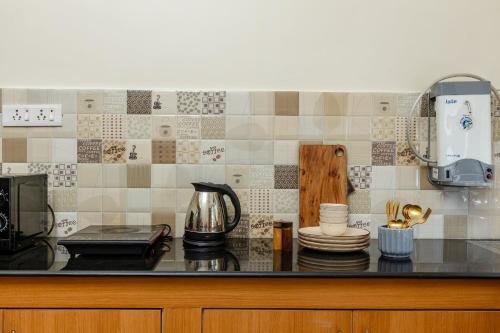 a kitchen with a counter top with a coffee maker at Mistral Holidays Near Trinity Beach & Benaulim Beach in Benaulim
