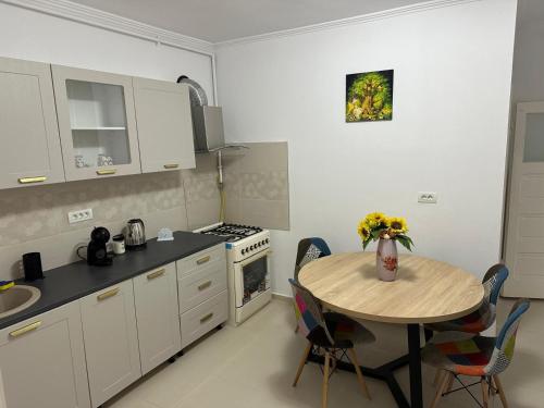 a kitchen with a table with a vase of flowers on it at Casa Grande in Făgăraş