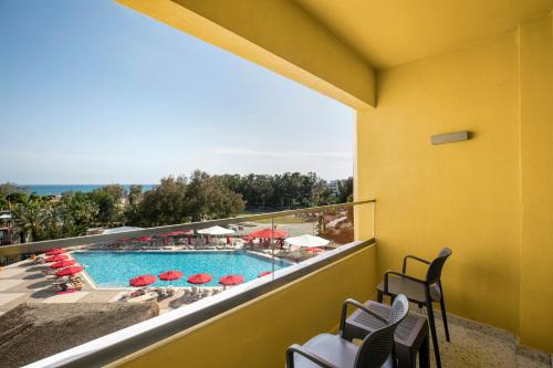 a balcony with a view of a pool and chairs at Megasaray Resort Side in Side