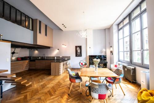 une cuisine et une salle à manger avec une table et des chaises dans l'établissement Loft Créqui - Bel appart spacieux proche Tête d'Or, à Lyon
