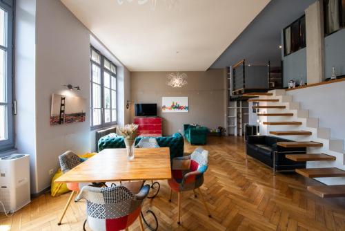 - un salon avec une table en bois et un escalier dans l'établissement Loft Créqui - Bel appart spacieux proche Tête d'Or, à Lyon