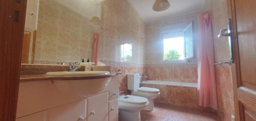 Un baño con inodoro, lavabo y ventana. en confortable villa at only 100 meter from the beach, supermarkets and the restaurants, en Calpe