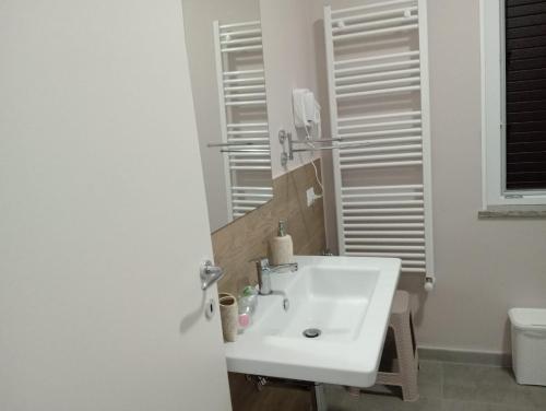 a bathroom with a white sink and a toilet at ARA HOME Comfort in Marcellinara