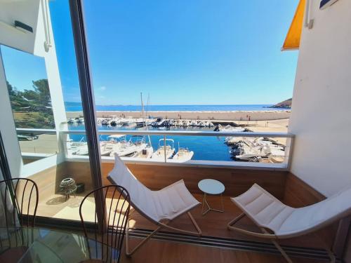 d'un balcon avec des chaises blanches et une vue sur le port de plaisance. dans l'établissement LE Duplex D'Athéna, à Bandol