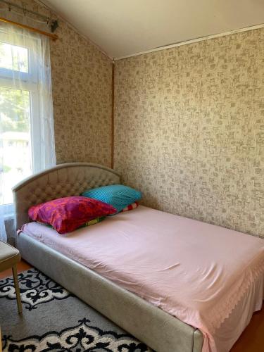 a bed with two pillows on it in a room at Vasaras mājiņa pie Rāznas ezera Nr 2 in Kaunata