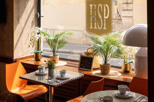 a table and chairs in front of a window with plants at Hôtel Saint Pierre in Paris