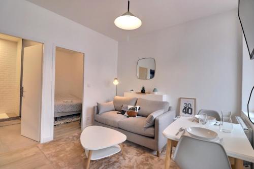 un salon avec un canapé et une table dans l'établissement Degemer - T1 Apartment in Charpennes - Villeurbanne, à Villeurbanne